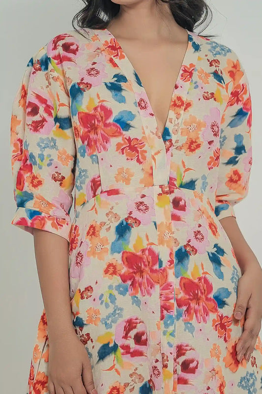 Close-up front view of an optic white linen halter dress featuring a vibrant celestial bloom floral print in shades of yellow, blue, and green, highlighting a unique asymmetric twisted keyhole neckline.