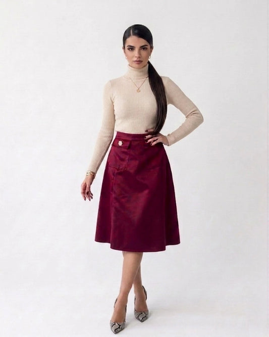 Full front view of a model standing with hands on hips, showcasing the tailored waist, elegant front pleats, and button-pocket design of the winery red suede skirt.