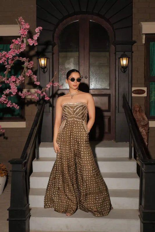 Full-length elegant front view of the strapless olive green silk jumpsuit with wide-leg trousers and intricate gold embroidery on the bodice.
